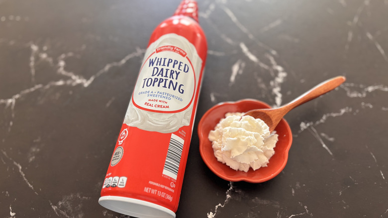Aldi Friendly Farms whipped cream can next to small bowl of whipped cream