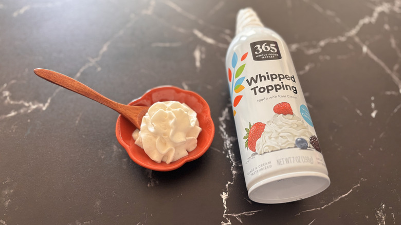 Small bowl of whipped cream next to 365 Whole Foods market whipped cream can