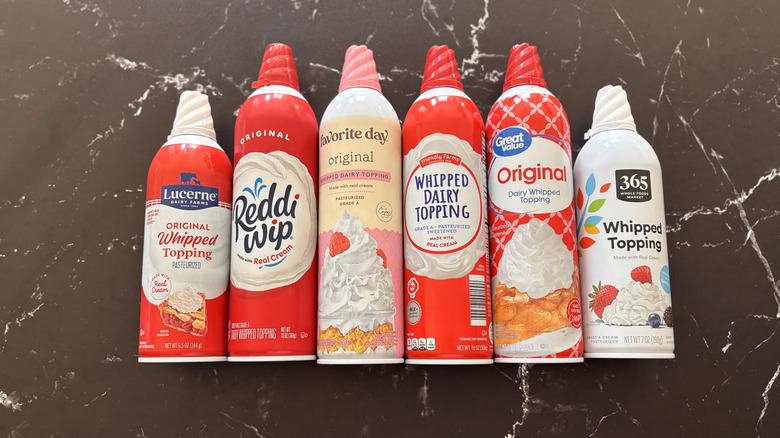 Various whipped cream cans lined up on countertop