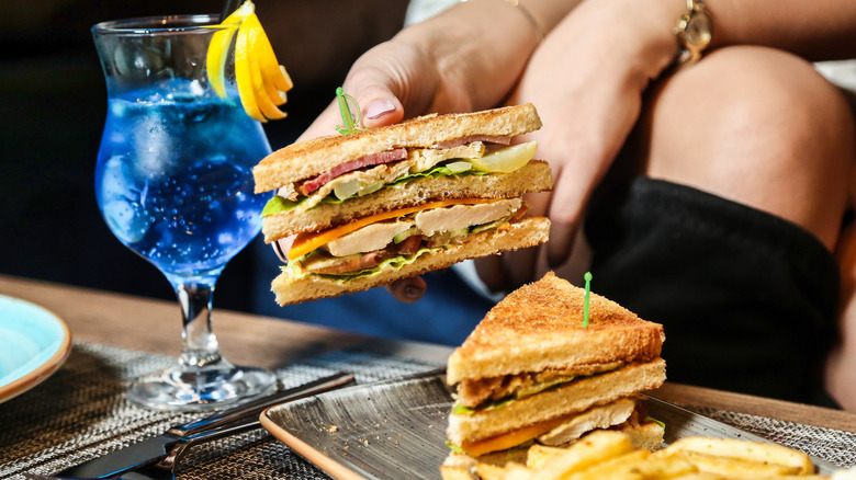 Person holding a club sandwich