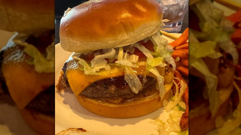Red Robin Whiskey River Barbecue Burger with a side of sweet potato fries sitting on a plate.
