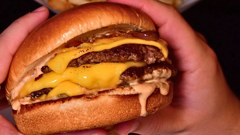 Someone holding the Wagyu Smashburger from Morton's The Steakhouse