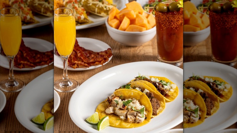 Assorted Tex-Mex dishes on table with cocktails