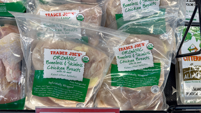 Packages of Trader Joe's boneless skinless chicken breasts in fridge at store