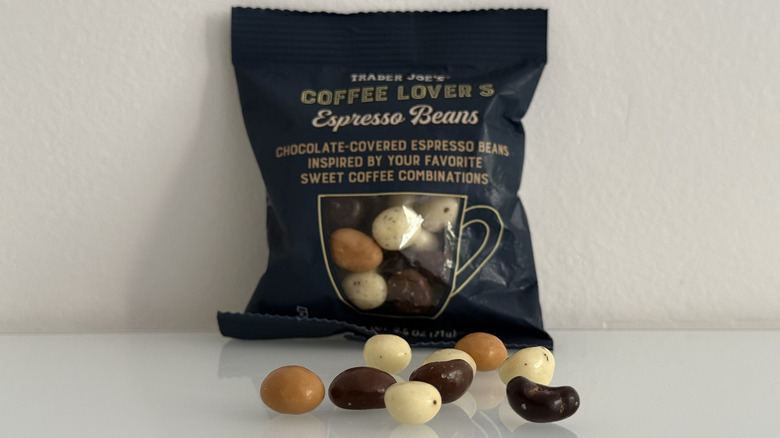 Chocolate covered coffee beans in four different flavors in front of small pouch