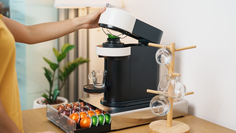 Person inserting coffee pods into machine