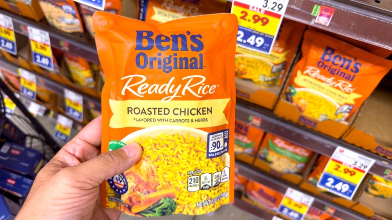 Person lifting pack of Uncle Ben's Original Ready Rice from grocery store shelf