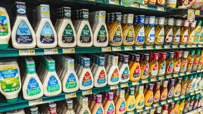 Grocery store shelf with a variety of bottled salad dressings