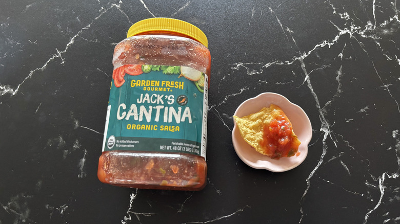 Costco salsa container next to chip and salsa sample on small plate