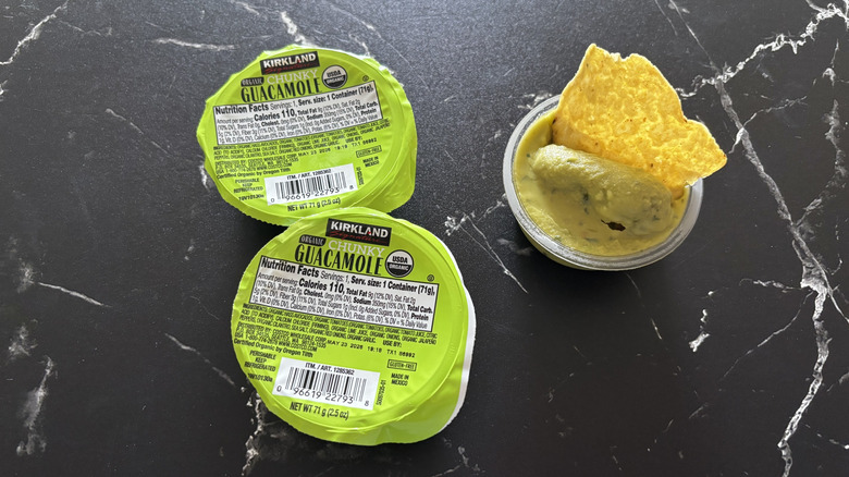 Kirkland guacamole single-serve containers next to open container with chip in it