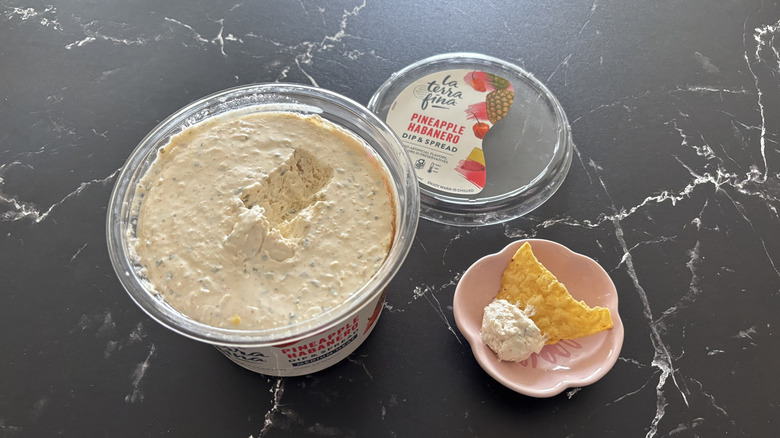 Costco pineapple habanero dip container next to chip and dip sample on small plate
