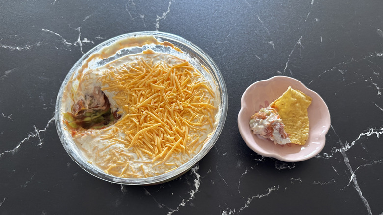Costco 6-layer dip container next to chip and dip sample on plate