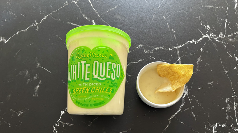 Costco white queso container next to chip and queso sample in small bowl