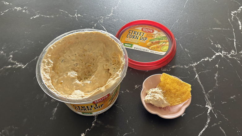 Costco street corn dip container next to chip and dip sample on small plate