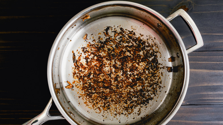 dirty steel sauce pan on wood background