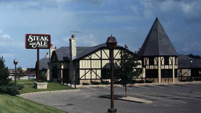 A building with steepled roofs and chimneys called "Steak and Ale"
