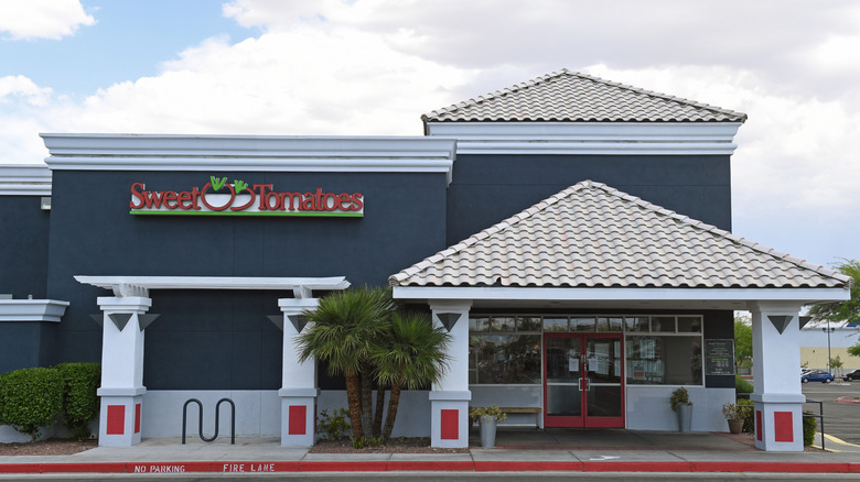 A blue an grey building with a sign that says Sweet Tomatoes