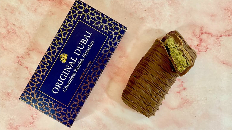 Lovetta Dubai chocolate package next to bar on pink marble surface