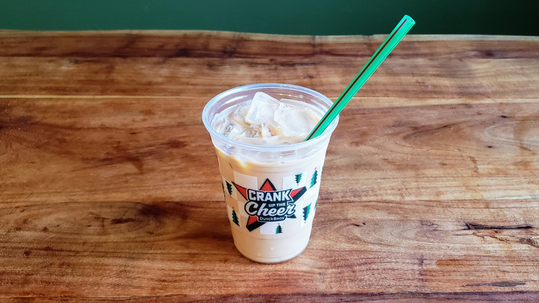 Dutch Bros Golden Eagle protein latte on a wood table.