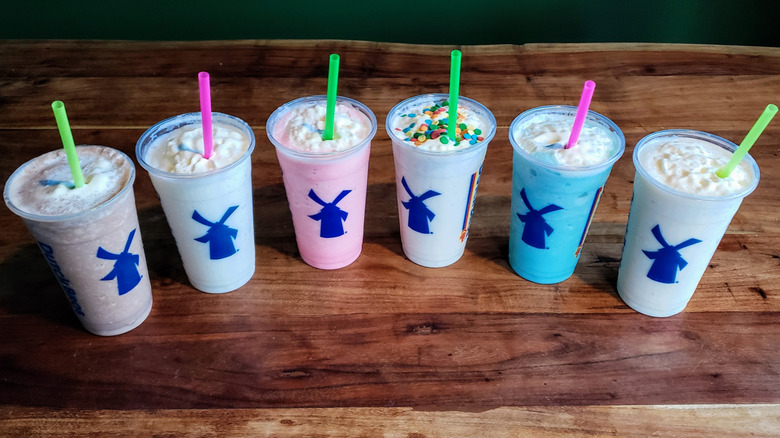All flavors of Dutch Bros shakes on a wooden table.