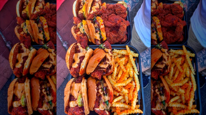 Hands holding to-go boxes of Dave's Hot Chicken tenders, sandwiches, and fries