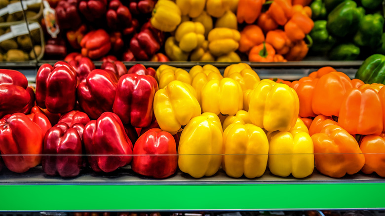 Red, yellow, orange, and green bell peppers in a grocery store