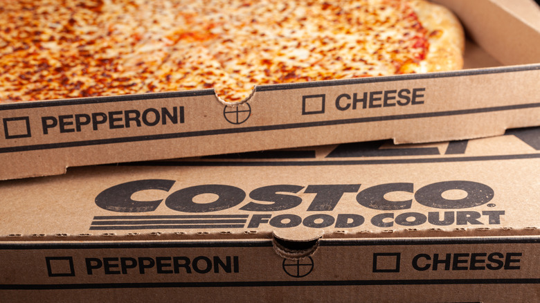 Close up of cheese pizza and box