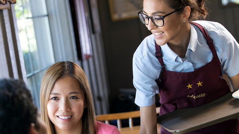 A Cracker Barrel waitress serving food to a customer