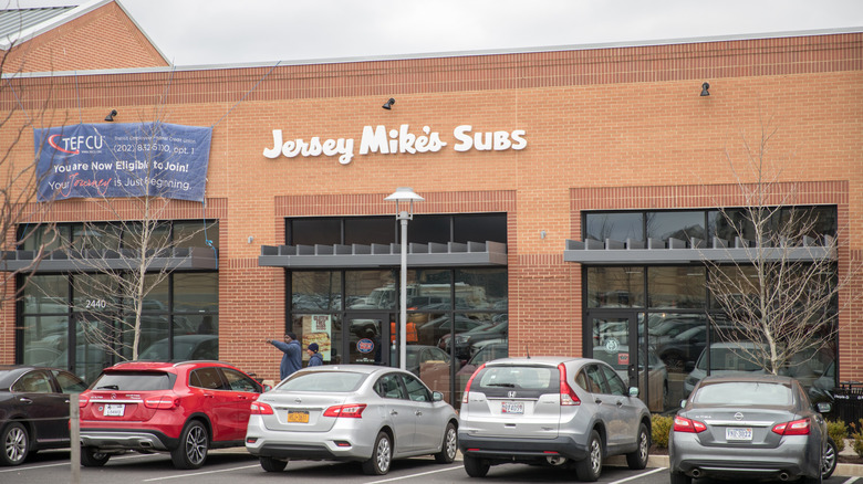 Cars parked outside the exterior of a Jersey Mike's restaurant