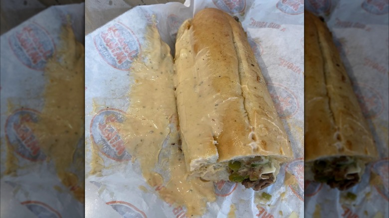 A messy, sloppy sandwich in Jersey Mike's wrapper, mirrored image