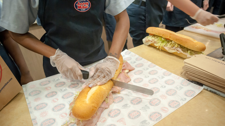 Worker slicing sandwich at a Jersey Mike's Subs