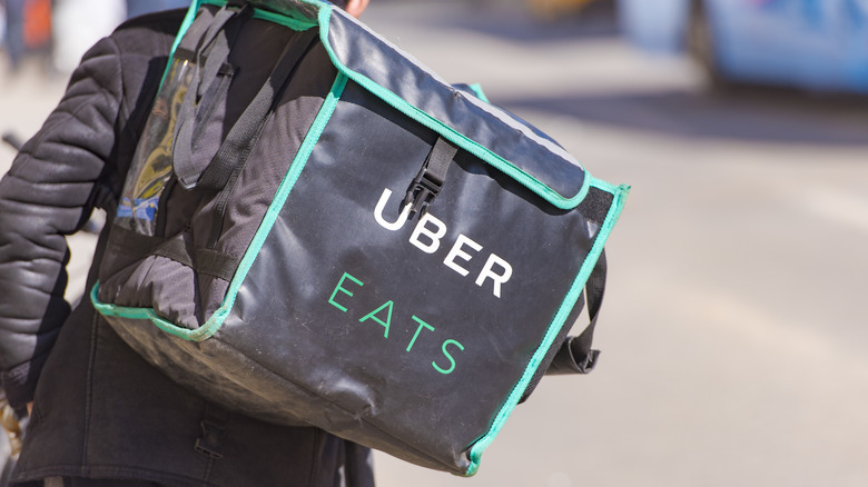 Close up of delivery driver wearing Uber Eats bag