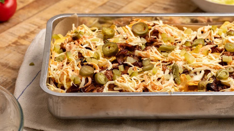 Large metal tray of BBQ pulled pork nachos