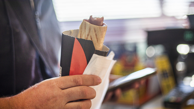 A hot dog from a gas station with a bite taken out.