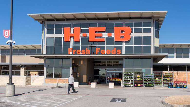 H-E-B sign on glass building against blue sky