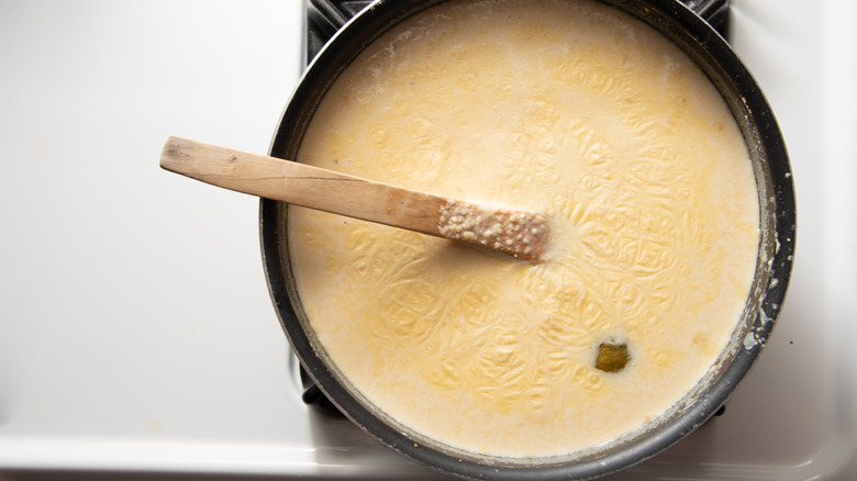 A dish of corn porridge with a wooden spoon sticking out of it
