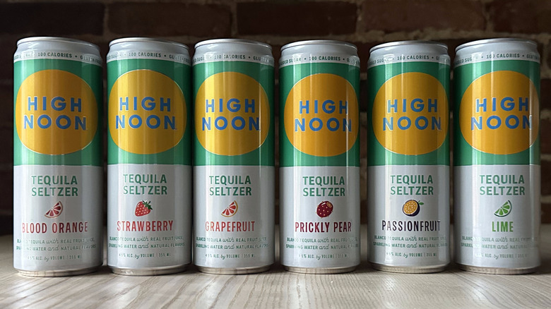 Cans of High Noon tequila seltzer on wooden table