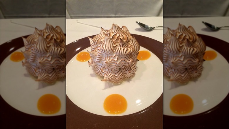 Mirrored image of Delmonico's baked Alaska on white and brown plate in restaurant