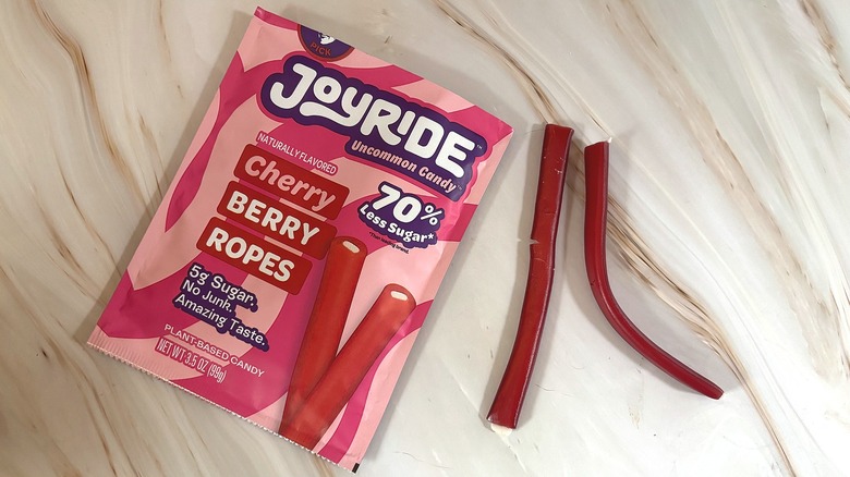 Two Joyride Cherry Berry ropes next to package of Joyride on marbled surface
