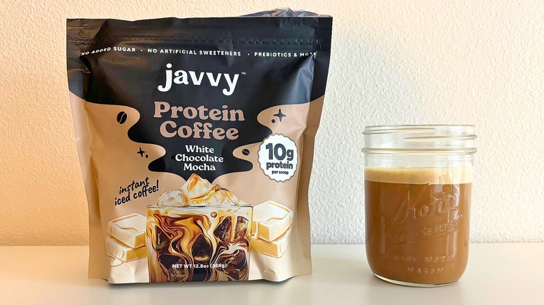 Bag of Javvy white chocolate mocha coffee mix next to kerr jar of coffee on white table