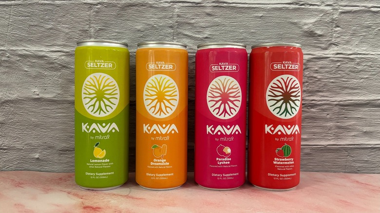 Four Mitra9 kava seltzers on grey background