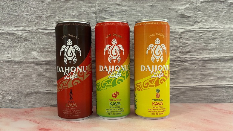 Three DaHonu Life Kava cans lined up on grey background