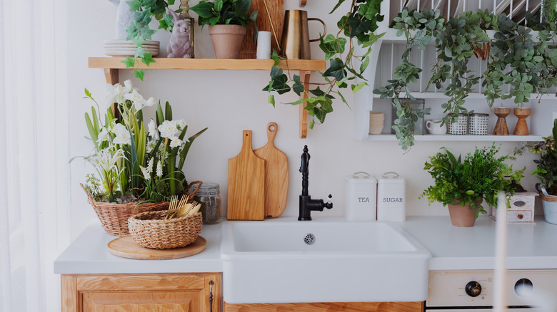 Greenery and woven baskets on white counter in kitchen