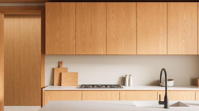 Bright kitchen showcasing wooden cabinetry, white countertops
