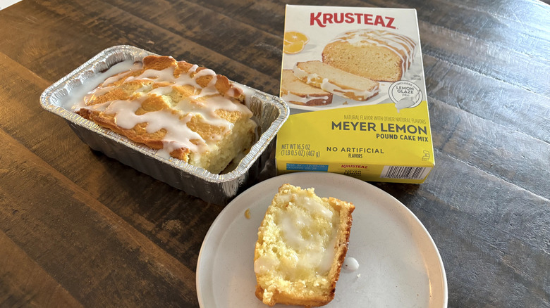Krusteaz lemon pound cake mix in a box next to a loaf in a tin and a slice on plate.