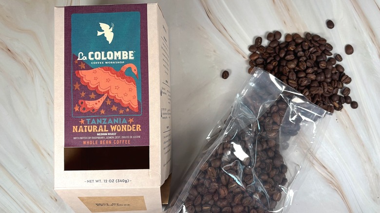 Box of La Colombe Tanzania Natural Wonder next to bag of beans spilling out onto table