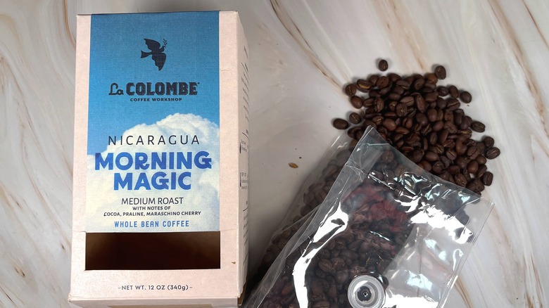 Box of La Colombe Nicaragua Morning Magic next to bag of beans spilling out onto table