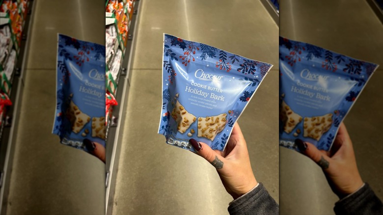 Hand holding bag of Choceur Cookie Butter Holiday Bark at store