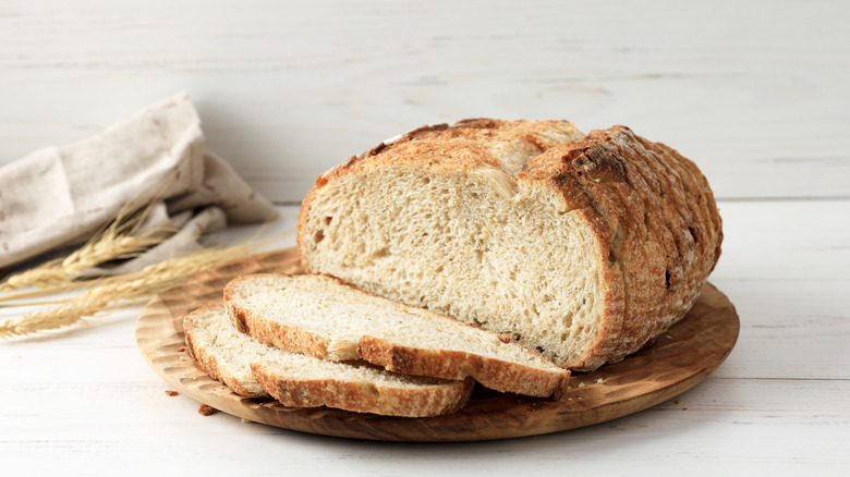 Sliced loaf of bread on wooden board