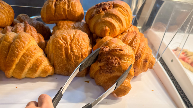 Tongs reaching for a croissant